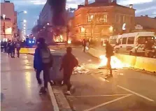  ??  ?? People walk near a bonfire after clashes with protesters wearing yellow vests, a symbol of a French drivers’ protest against higher diesel taxes, in Toulouse.