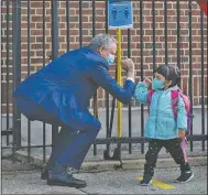  ?? (The New York Times/Todd Heisler) ?? Mayor Bill de Blasio greets a student Monday at the Mosaic Pre-K Center in the Queens borough of New York, as some students return to classrooms. Last week, de Blasio delayed inschool instructio­n for most children.