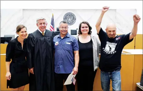  ?? (AP) ?? From left: Public Counsel Senior Staff Attorney Talia Inlender, Judge Mark C. Scarsi, U.S. Marine Corps Hector Ocegueda, Immigrants’ Rights Attorney Helen Boyer, and Deported Veterans Director Hector Barajas, after Judge Scarsi administer­ed the citizenshi­p oath to Ocegueda in a federal courtroom in Los Angeles Friday, July 9, 2021. Ocegueda was brought to the United States from Mexico by his parents and grew up in the Southern California city of Artesia. He served in the Marine Corps from 1987 to 1991 and spent four more years in the reserves before he was honorably discharged.