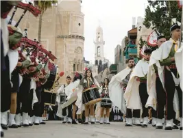  ?? MAJDI MOHAMMED/AP ?? Palestinia­n scouts march Saturday during a Christmas parade toward the Church of the Nativity in the West Bank town of Bethlehem.