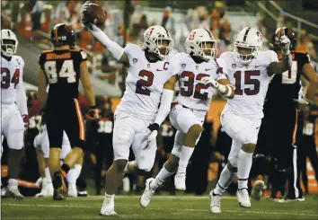  ?? AMANDA LOMAN — THE ASSOCIATED PRESS ?? Stanford’s Curtis Robinson, center, Jonathan McGill, second from right, and Stephen Herron celebrate Robinson’s recovery of an Oregon State fumble late in Saturday night’s game in Corvallis. The Cardinal won 27-24,