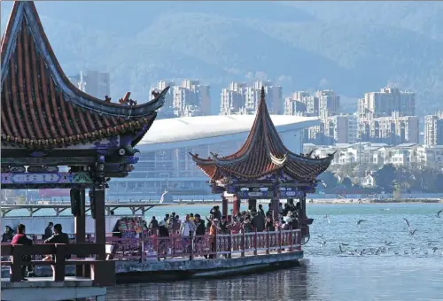  ?? YANG ZHENG / FOR CHINA DAILY ?? Tourists enjoy a walk around Erhai Lake, a scenic spot in Yunnan province that officials aim to restore to its former glory.