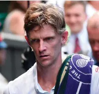  ??  ?? Novak Djokovic lifts the trophy after celebratin­g his victory by chewing some of the Centre Court grass as a shattered Kevin Anderson reflects on his defeat