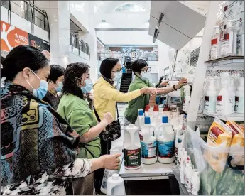  ?? LAM YIK FEI/THE NEW YORK TIMES ?? Evidence that deep cleaning lessens the threat of the virus indoors is scarce. Above, people buy cleaner in Hong Kong.