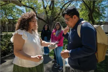  ?? PHOTO BY JOSÉ LUIS VILLEGAS FOR CALMATTERS ?? Carlos Morales and Michelle Villegas-Frazier participat­e in a sage burning ritual outside of the Native American Academic Student Success Center at UC Davis on April 1.