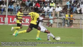  ??  ?? Highlander­s striker Prince Dube makes an attempt at goal with Chicken Inn midfielder Simon Munawa closing in