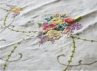  ??  ?? ABOVE FROM LEFT An early 20th-century embroidere­d tablecloth featuring bouquets of flowers. This beautiful quilt made by Jane Brocket is an ingenious way to bring new life to vintage tablecloth­s, napkins and tray cloths.