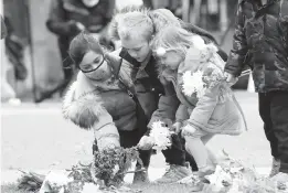  ?? GARETH FULLER/PA MEDIA ?? Children leave flowers Saturday at Windsor Castle, one day after the death of Britain’s Prince Philip. His royal funeral at the castle will be Saturday.