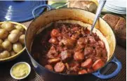  ??  ?? Pork simmers in a Dutch oven or slow cooker with cabbage and sauerkraut. Kielbasa is added near the end of cooking.