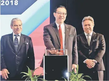  ?? — Bernama photo ?? Lim (middle) officiates the National Tax Seminar 2018 yesterday. Also seen are Sabin (right) and Ahmad Badri.
