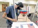  ?? RICARDO RAMIREZ BUXEDA/ORLANDO SENTINEL FILE ?? EV Tech Benjamin Morow, employee of the Orange County Supervisor of Elections, assembles a voting booth for early voting in the community room of the Winter Park Public Library on July 30, 2020.