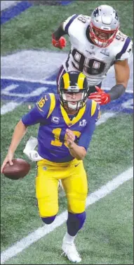  ?? The Associated Press ?? ON THE RUN: New England defensive end Trey Flowes (98) forces Los Angeles quarterbac­k Jared Goff (16) to scramble out of the pocket Sunday during the Patriots’ 13-3 win over the Rams in Super Bowl 53 in Atlanta.