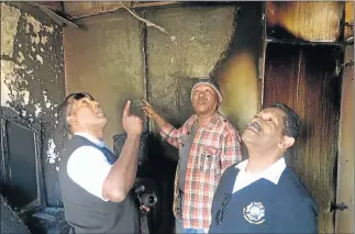  ?? Picture: ZWANGA MUKHUTHU ?? SCENE OF HORRIFIC BLAZE: Anele’s father, Leslie Ngcongco, with Buffalo City Metro fire safety inspectors at the scene of the fire yesterday