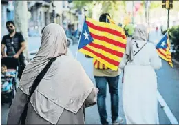  ?? XAVIER CERVERA ?? Dos mujeres musulmanas llevan estelades en el paseo de Gràcia