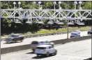  ?? Associated Press ?? Cars pass under toll sensor gantries hanging over the Massachuse­tts Turnpike in Newton, Mass.