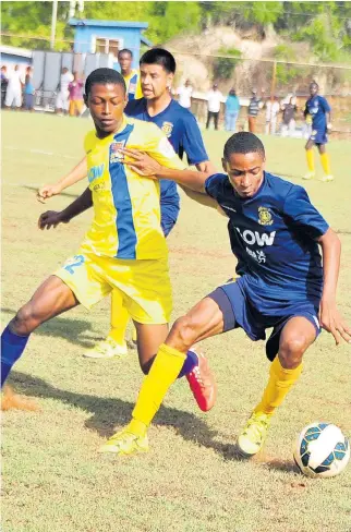  ??  ?? Munro’s Timar Lewis (right) moves away from a tackle made by STETHS’s Aldane Barrett in their ISSA/FLOW daCosta Cup Group E clash at Alpart. STETHS won the match 1-0.