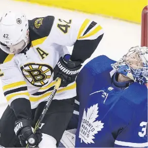  ??  ?? Toronto goaltender Frederik Andersen takes an elbow to the head from Boston’s David Backes during Game 6 on Monday night at Toronto’s Air Canada Centre. Andersen was spectacula­r at times as the Leafs won 3-1.