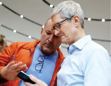  ??  ?? Apple CEO Tim Cook and Apple Chief Design Officer Jonathan Ive look at the new Apple iPhone X during an Apple special event on Tuesday in Cupertino, California. (AFP)