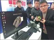  ?? WU LAN / CHINA NEWS SERVICE ?? Feng Haihong, CEO of Anhui MiMouse Technology, introduces the company’s intelligen­t voice-controlled mouse, which can type and translate, in Hefei, Anhui province, in December.