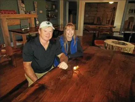  ?? PHOTO SPECIAL TO THE DISPATCH BY MIKE JAQUAYS ?? Kenny, left, and Laurie Wellington sit at one of their wood crafted tables Nov. 3in their Wellington Woods showroom on Route 20in Madison.