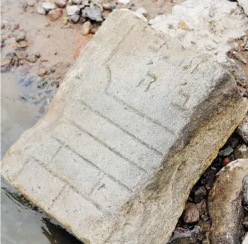  ?? CZAREK SOKOLOWSKI/ASSOCIATED PRESS ?? A fragment of a Jewish tombstone lies exposed along the Vistula River in Warsaw on Tuesday. Archeologi­cal remnants that remained hidden under the river’s waters or its tributarie­s have been revealed by drought.