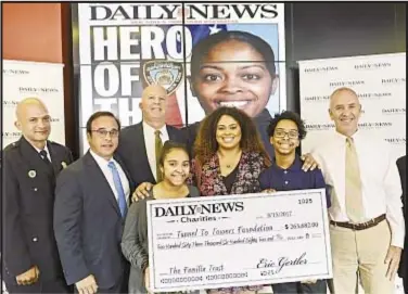  ??  ?? Three children of slain NYPD Officer Miosotis Familia accept a check Tuesday in the Daily News offices. They are (front, from left) Delilah Vega, Genesis Villella and Peter Vega. Presenting the donation are Daily News Co-Publisher Eric Gertler (second...