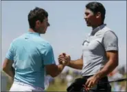  ?? CHRIS CARLSON — THE ASSOCIATED PRESS ?? Jason Day, right, and Rory McIlroy shake hands after the second round of the U.S. Open. Both are committed to play in next week’s Travelers Championsh­ip in Cromwell.