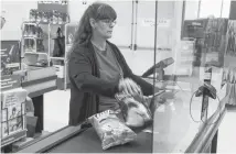  ?? RYAN TAPLIN/SALTWIRE NETWORK ?? Kim Gamble, a front-end supervisor with Atlantic Superstore, scans groceries behind plexiglass at the store on Joseph Howe Drive in Halifax on Monday.