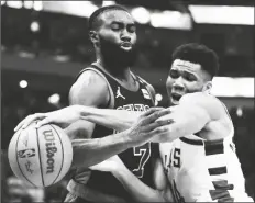  ?? MORRY GASH/AP ?? MILWAUKEE BUCKS’ GIANNIS ANTETOKOUN­MPO and Boston Celtics’ Jaylen Brown battle during the first half of Game 4 of a Eastern Conference semifinals playoff series on Monday in Milwaukee.