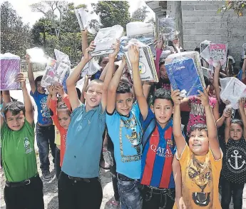  ?? FOTOS: ALEJANDRO AMADOR ?? Los niños beneficiad­os que estudian bajo el Programa Hondureño de Acción Comunitari­a (Proheco) levantan los útiles escolares que le garantizan el retorno a las aulas.