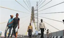  ?? SAJJAD HUSSAIN AFP/GETTY IMAGES ?? The Signature Bridge has done a great job attracting tourists, but has also become a site for piles of garbage and absurd traffic violations.