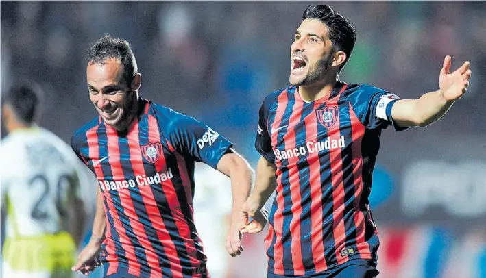  ?? JUANO TESONE ?? Dúo dinámico azulgrana. Fernando Belluschi y Nicolás Blandi festejan de la mano el 2-0 de San Lorenzo luego de una asistencia de lujo del mediocampi­sta al delantero.