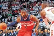  ?? KEVIN C. COX/GETTY IMAGES ?? The Wizards’ John Wall drives against the Hawks’ Paul Millsap. Wall missed12 of 15 shots and finished with 12 points.