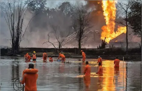  ?? AFP ?? Rescue workers recover a body after an explosion at a well run by state-owned Oil India Ltd in Tinsukia, the northeaste­rn state of Assam, on Wednesday. Two workers have been found dead near the site of a huge fire ignited by gas that has been spewing from an oil field in India for two weeks.