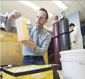  ?? JOHN ULAN ?? University of Alberta assistant professor Daniel Alessi examines flowback water in his lab. U of A researcher­s are looking for ways to make the practice of fracking more environmen­tally friendly.