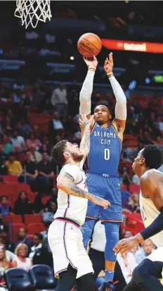  ?? AP ?? Russell Westbrook (0) takes a shot against Miami Heat guard Tyler Johnson (left) and centre Hassan Whiteside (21).