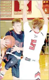  ?? PHOTO BY RICK PECK ?? McDonald County’s Boston Dowd looks to get of a shot off while being defended by Aurora’s Zach Shoemaker during the Hound Dogs’ 58-26 win the semifinals of the Missouri Class 4 District 10 Basketball Tournament at MCHS.