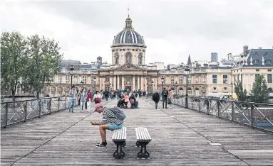  ?? JOANN PAI THE NEW YORK TIMES ?? A magnet for Paris picnickers, the Pont des Arts links the Louvre to the Institut de France, home of the Académie Française.