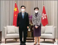  ?? (AP/Anthony Kwan) ?? Hong Kong Chief Executive-elect John Lee (left) and Chief Executive Carrie Lam pose for a photo during a meeting Monday at the Central Government Complex ahead of a news conference in Hong Kong.