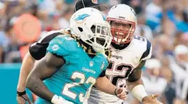  ??  ?? Dane Fletcher has words with Jay Ajayi of the Dolphins in the fourth quarter against the New England Patriots at Sun Life Stadium in Miami Gardens Sunday.