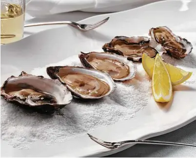  ?? E. Jason Wambsgans / Chicago Tribune ?? Oysters make the simplest starter for a seafood feast — just shuck and eat. Add a bottle of bubbly and a main course of mussels.