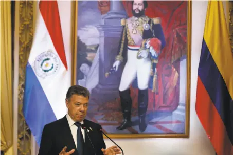  ?? Jorge Saenz / Associated Press ?? Standing by a painting of national hero Francisco Solano Lopez, President Juan Manuel Santos is a respected global leader.