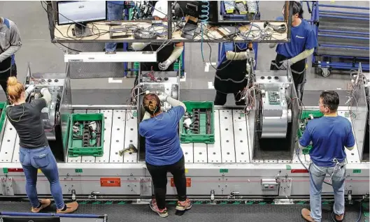  ?? Steve Gonzales / Houston Chronicle ?? Workers assemble air-conditioni­ng units in the new Daikin plant in Waller. Manufactur­ers have shown some growth in the area.