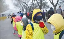  ??  ?? A GROUP of pupils wearing masks wait to undergo security checks as they visit the National Museum in Beijing on Dec. 21.