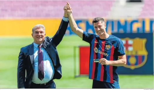  ?? EUROPA PRESS ?? Joan Laporta alza el brazo de Lewandowsk­i durante la populista presentaci­ón del delantero polaco en el Camp Nou.