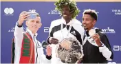  ?? ELSA Getty Images ?? Second-place finisher Mohamed Reda El Aaraby of Morocco takes a selfie with winner Albert Korir of Kenya and third-place finisher Eyob Faniel of Italy after the TCS New York City Marathon on Sunday.