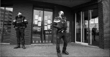  ??  ?? Bewakers bij het gemeentehu­is van Beverwijk. (Foto: De Telegraaf)