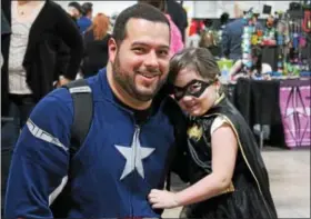  ?? OSCAR GAMBLE— DIGITAL FIRST MEDIA ?? A father dressed as Captain America and his daughter dressed as Batgirl visit The Great Philadelph­ia Comic Con! at the Greater Philadelph­ia Expo Center in Oaks, Saturday April 4, 2015.