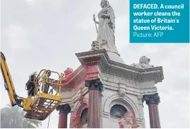  ?? Picture: AFP ?? DEFACED. A council worker cleans the statue of Britain's Queen Victoria.
