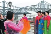  ?? YU HAIYANG / FOR CHINA DAILY ?? Tourists dressed in Korean ethnic garb pose in front of the Yalu River in Dandong, Liaoning province, on May 1.